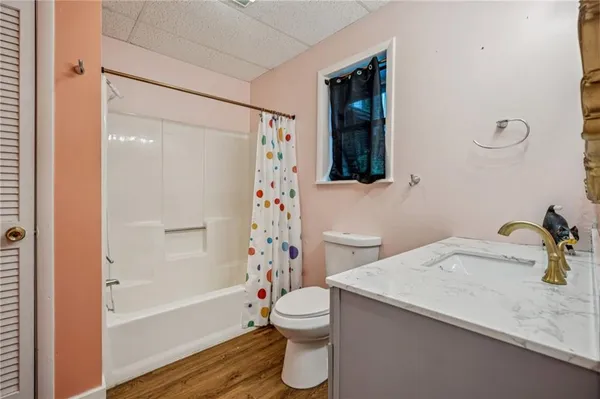 a bathroom with a sink a mirror and wooden floor