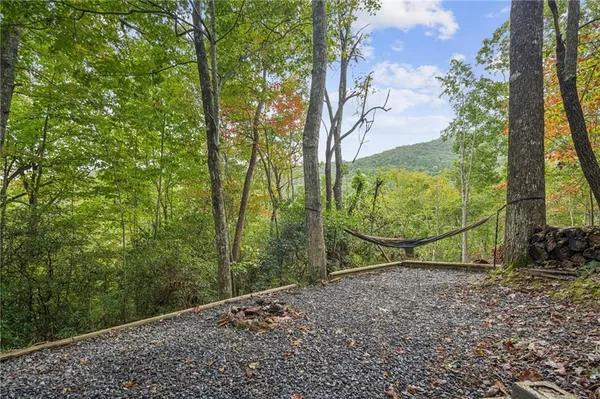 a view of a dirt road with trees in the background