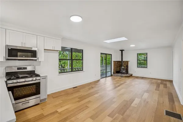 a view of an empty room with a window and a fireplace