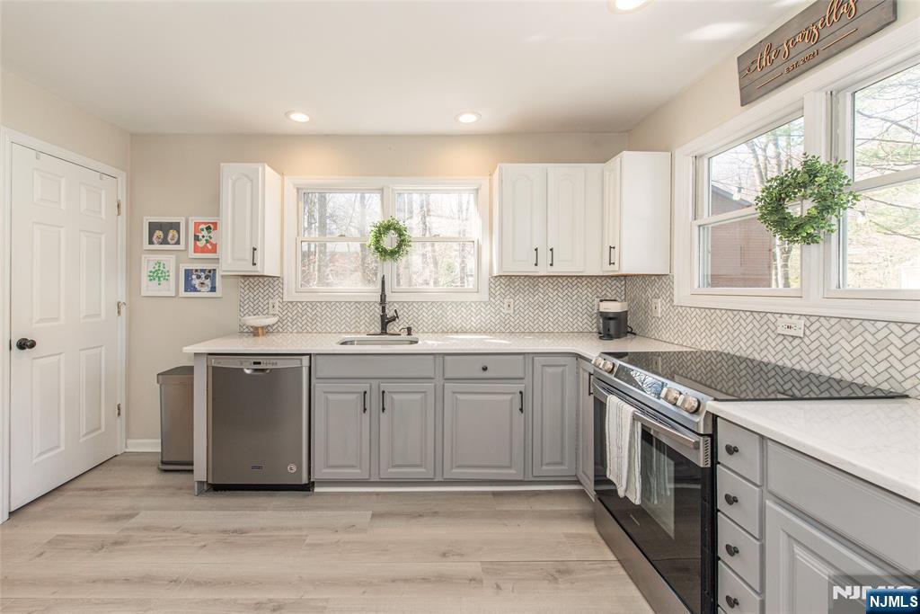 15 Orange Road Denville, NJ 07834 - Photo 10 of 24 a kitchen with stainless steel appliances granite countertop a sink a stove a refrigerator and a window