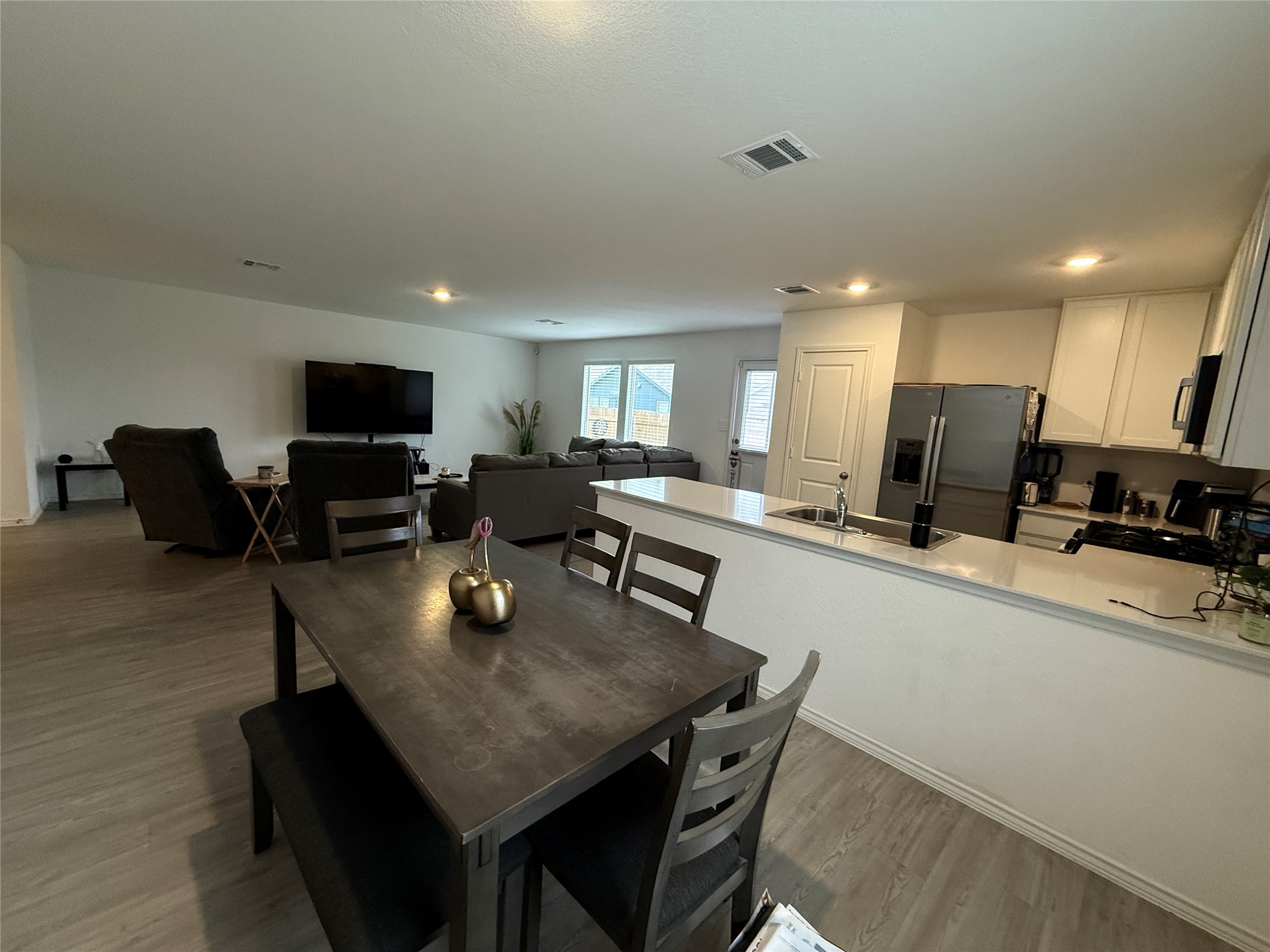 23420 Tiny Moons Way Elgin, TX 78621 - Photo 4 of 22 a kitchen with a dining table chairs microwave and cabinets