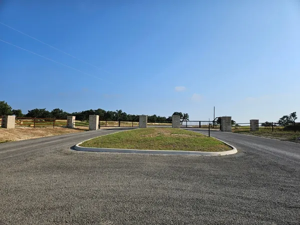 a view of a road with a building and trees in the background