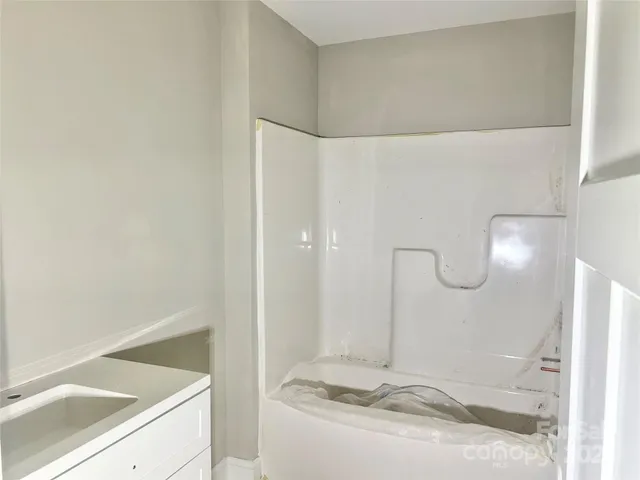 a bathroom with a tub sink and a mirror