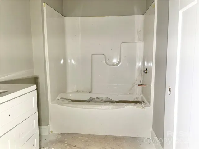 a bathroom with a granite countertop sink a mirror and shower