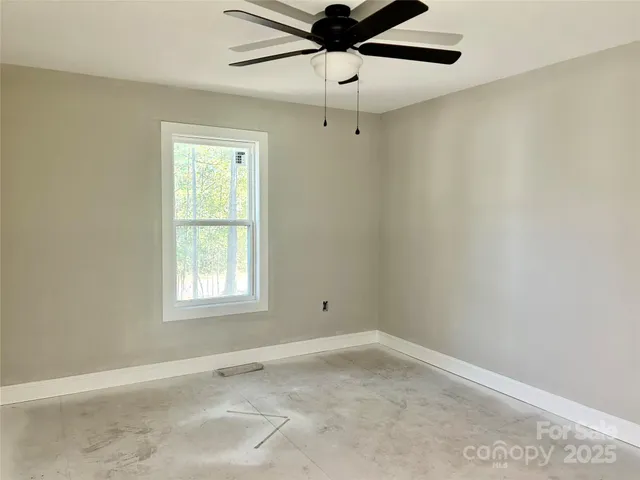 an empty room with a window and a fan
