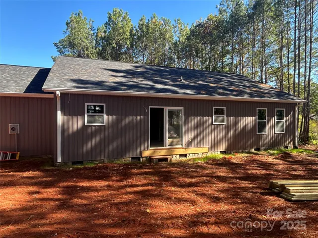 a backyard of a house with yard table and chairs