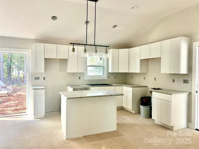 a kitchen with kitchen island a stove a sink a center island and cabinets