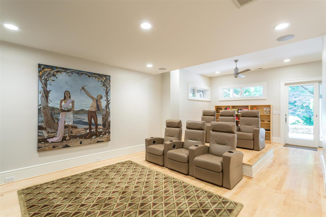 1117 Baslow Brook Court Raleigh, NC 27614 - Photo 29 of 30 The lower-level media room features surround sound, 6 reclining theater chairs(3 on a raised platform, and a sliding glass door to the patio. The back of the room has a reading nook and play area. Media Room/Recreation Room