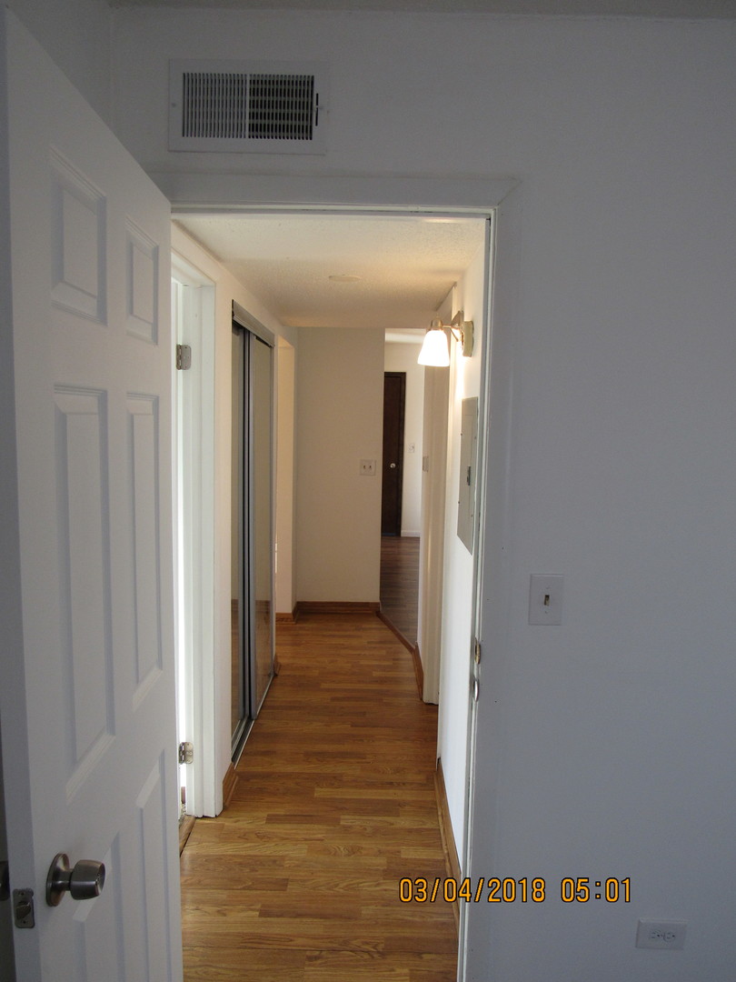 566 Timber Ridge Drive, Unit 302A Carol Stream, IL 60188 - Photo 8 of 14 a view of a hallway with wooden floor and closet
