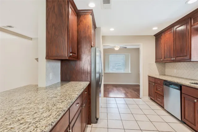 a kitchen with granite countertop a sink a stove and cabinets