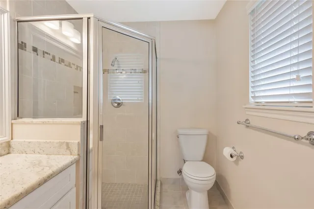 a bathroom with a granite countertop toilet a sink and shower