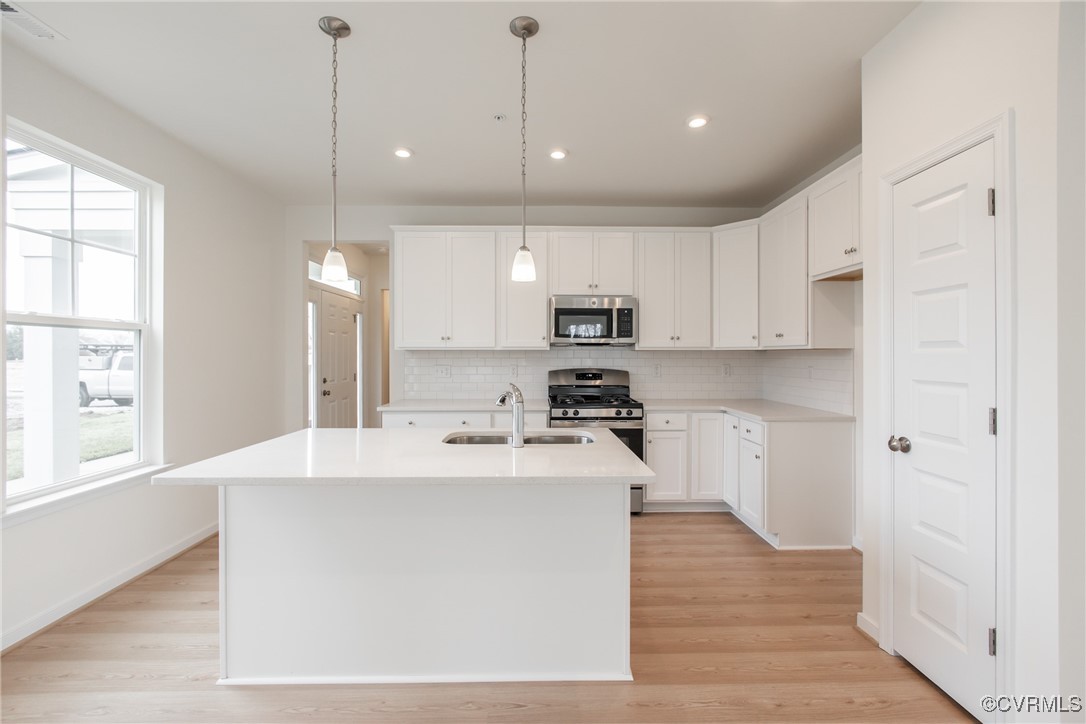 5320 Good Landing Road, Unit 103 Glen Allen, VA 23059 - Photo 5 of 37 a kitchen with stainless steel appliances kitchen island a sink a stove a refrigerator and white cabinets