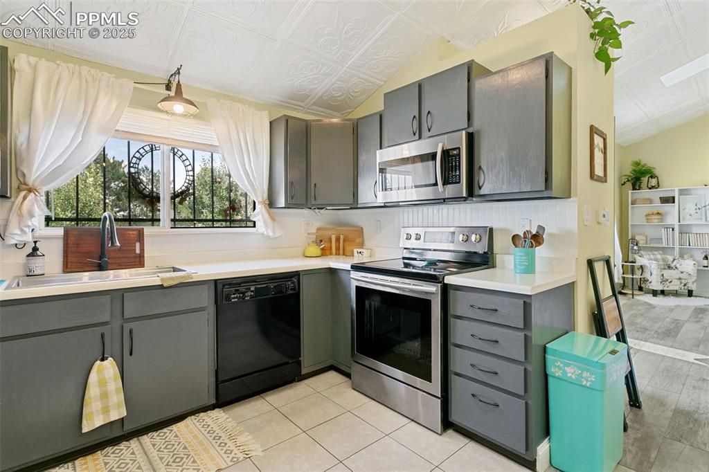 2960 Rio Vista Drive Colorado Springs, CO 80917 - Photo 11 of 32 a kitchen with stainless steel appliances granite countertop a stove a sink and a microwave