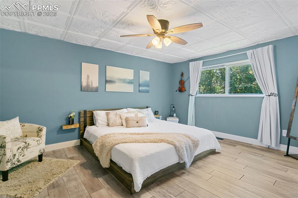 2960 Rio Vista Drive Colorado Springs, CO 80917 - Photo 15 of 32 a bedroom with a bed and a chandelier