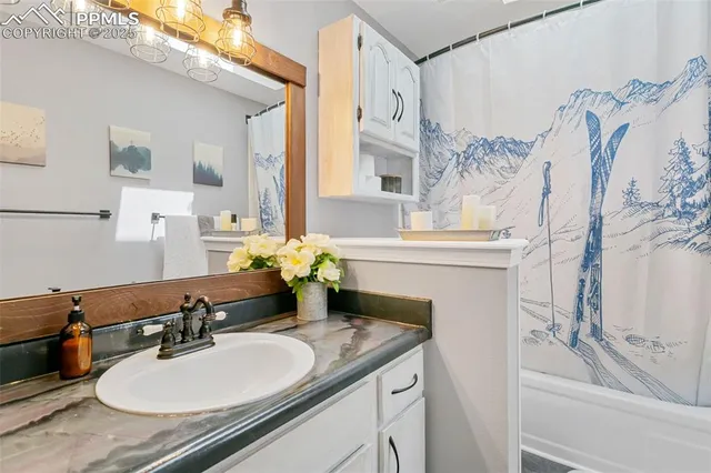 a bathroom with a sink vanity granite tub and a mirror
