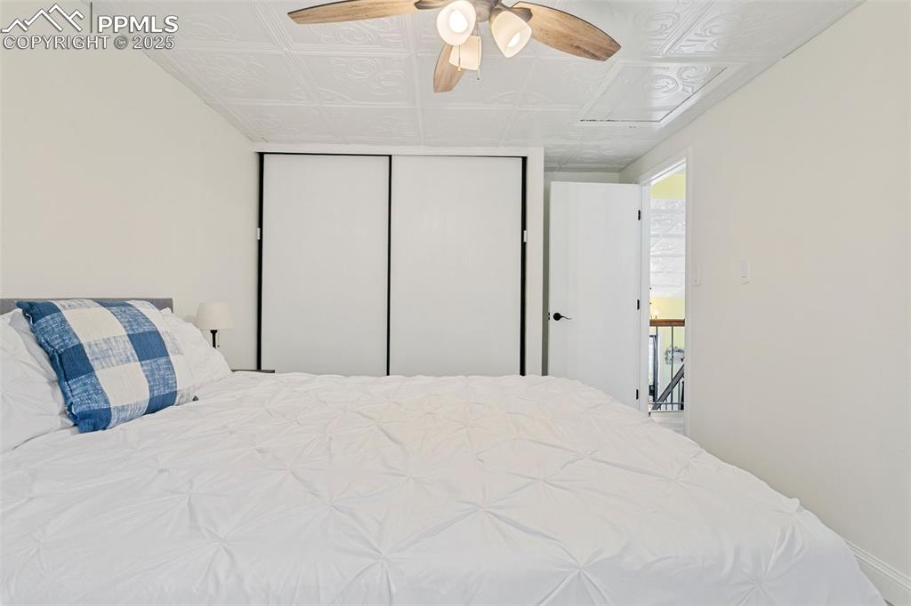 2960 Rio Vista Drive Colorado Springs, CO 80917 - Photo 20 of 32 a bedroom with a large bed and a chandelier