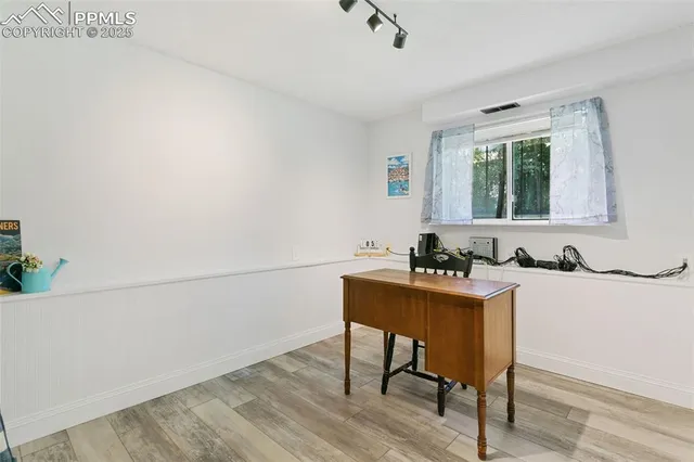a view of a workspace with furniture and a window
