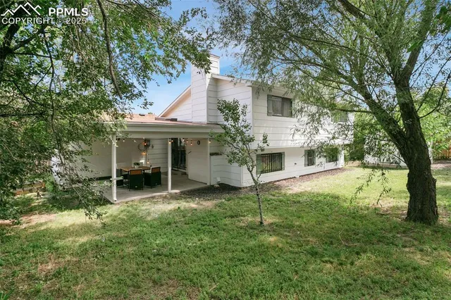 a view of a house with a yard and sitting area
