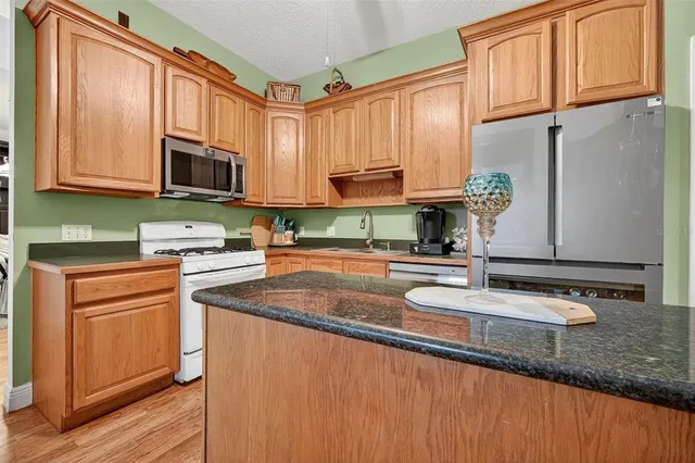 a kitchen with stainless steel appliances granite countertop a sink stove and microwave