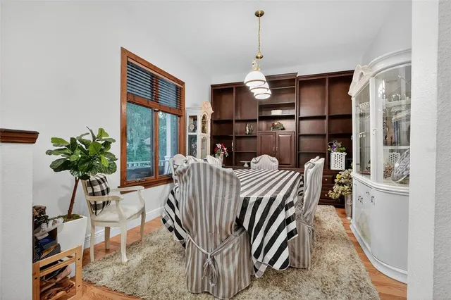 a living room with furniture a chandelier and a dining table