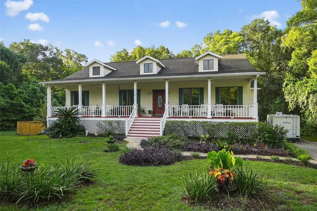 a front view of a house with a yard and potted plants