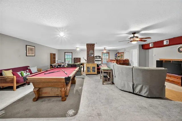 a living room with furniture a flat screen tv and kitchen view