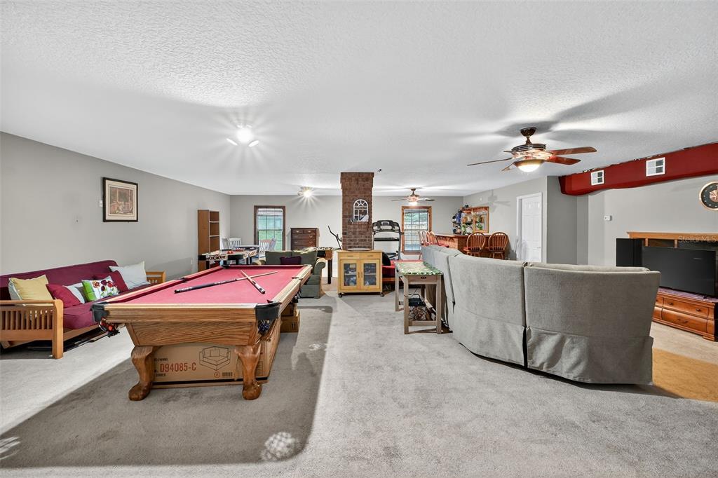 2836 Shenandoah Road DeLand, FL 32720 - Photo 31 of 46 a living room with furniture a flat screen tv and kitchen view