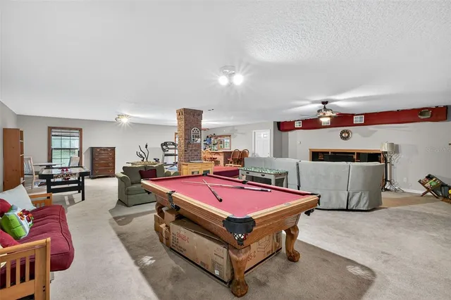 a living room with furniture pool table and flat screen tv