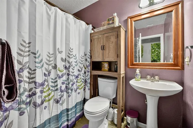 a bathroom with a sink toilet and mirror