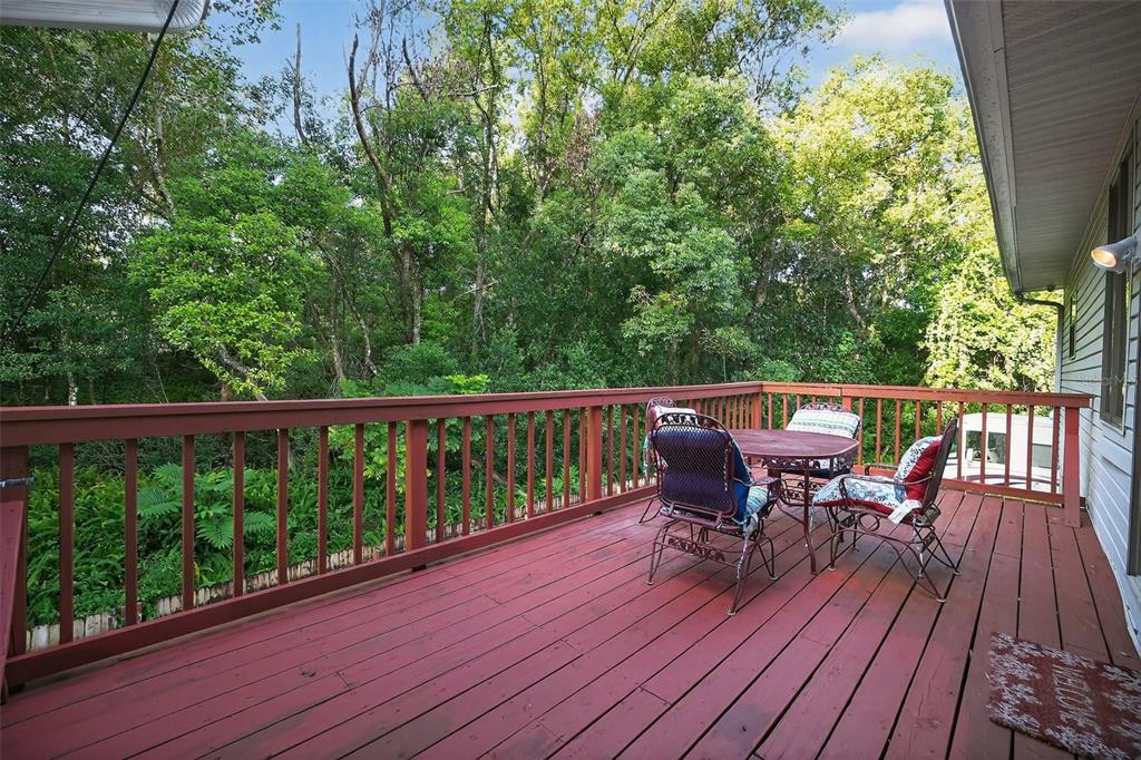 2836 Shenandoah Road DeLand, FL 32720 - Photo 38 of 46 a view of a deck with table and chairs and wooden floor