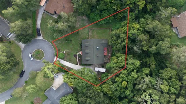 an aerial view of a house with a yard and a lake view