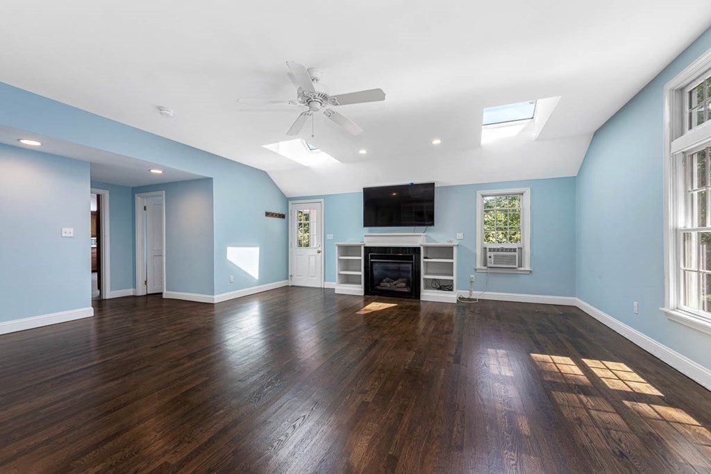 2 King George Drive Boxford, MA 01921 - Photo 24 of 41 an empty room with wooden floor fireplace and windows