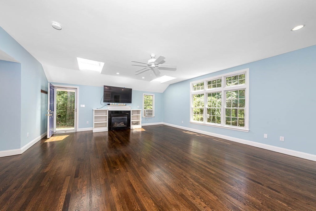 2 King George Drive Boxford, MA 01921 - Photo 27 of 41 an empty room with wooden floor fireplace and windows