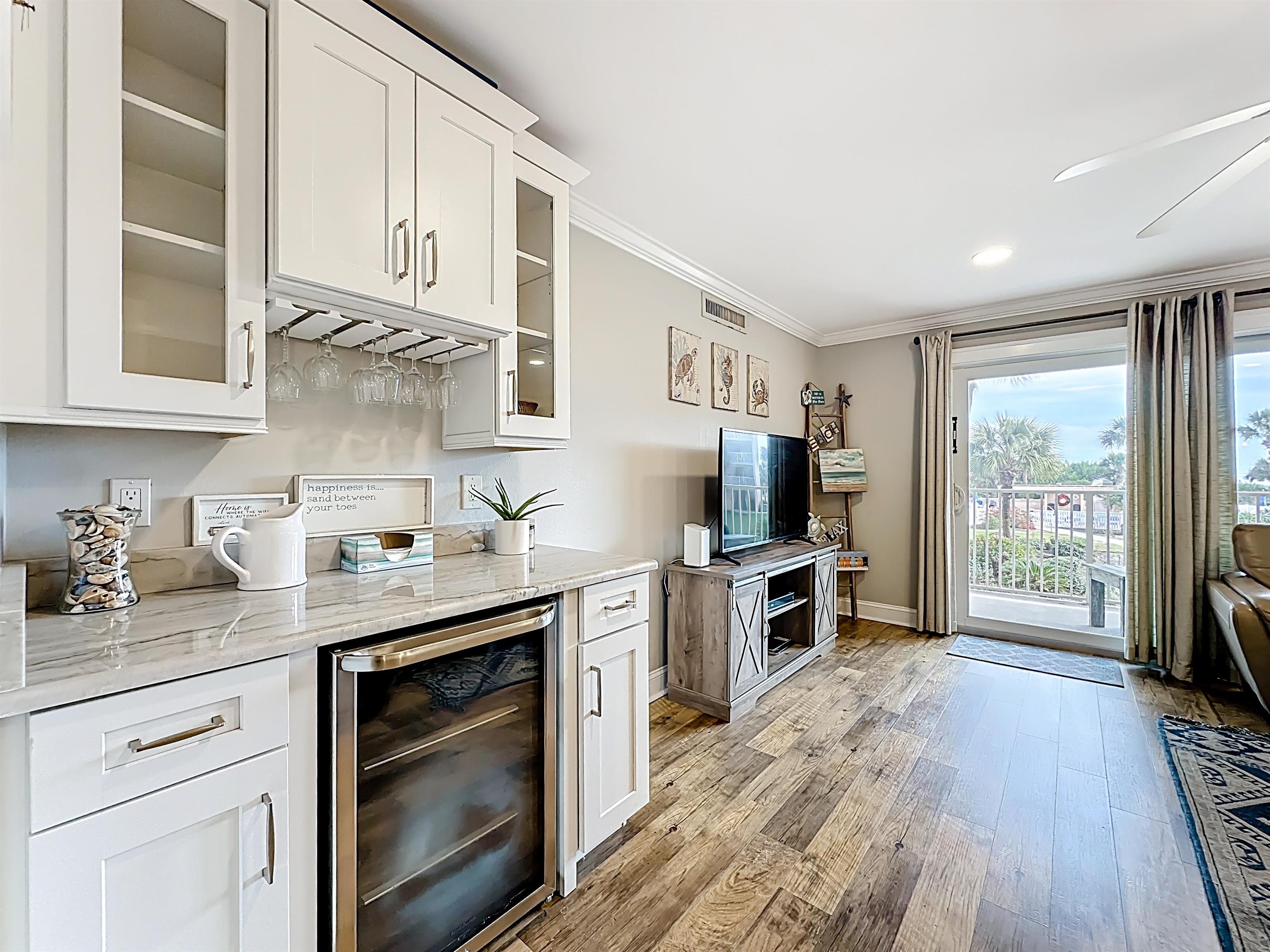 4 Ocean Trace Road, Unit 213 St. Augustine, FL 32080 - Photo 14 of 38 a kitchen with granite countertop a stove top oven a sink dishwasher and white cabinets with wooden floor