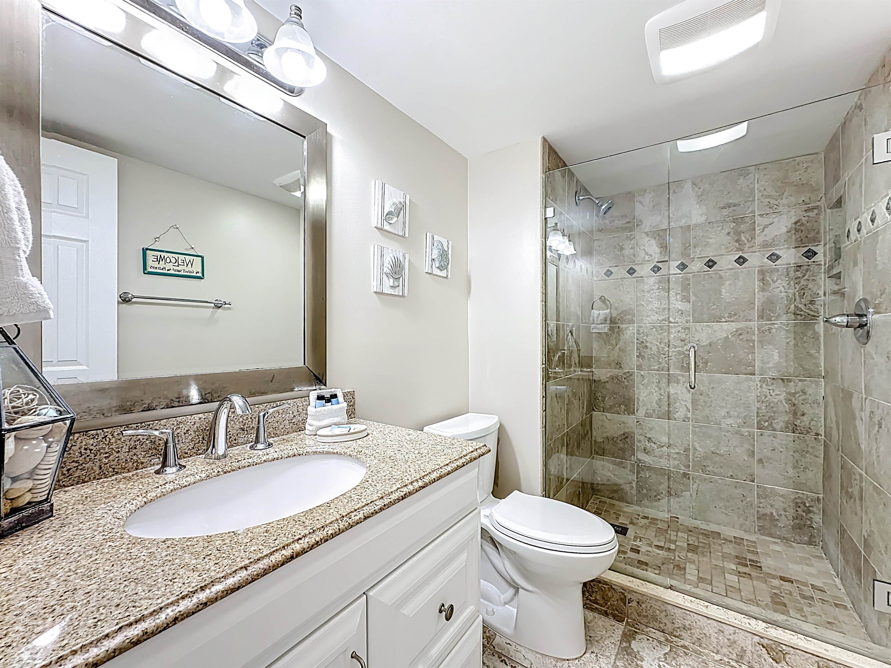 4 Ocean Trace Road, Unit 213 St. Augustine, FL 32080 - Photo 28 of 38 a bathroom with a shower sink vanity mirror and toilet
