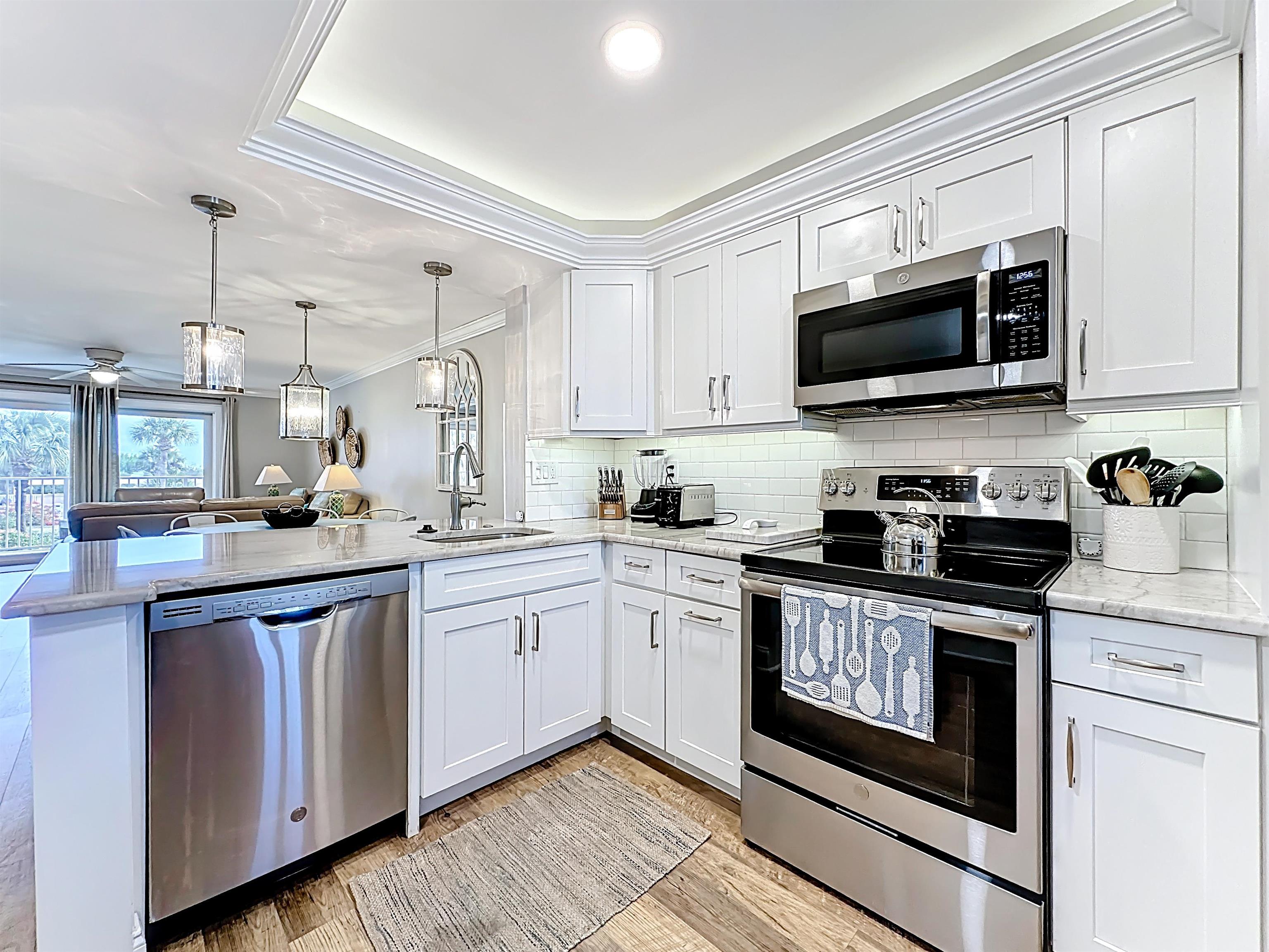 4 Ocean Trace Road, Unit 213 St. Augustine, FL 32080 - Photo 6 of 38 a kitchen with stainless steel appliances granite countertop grey cabinets a sink and a stove
