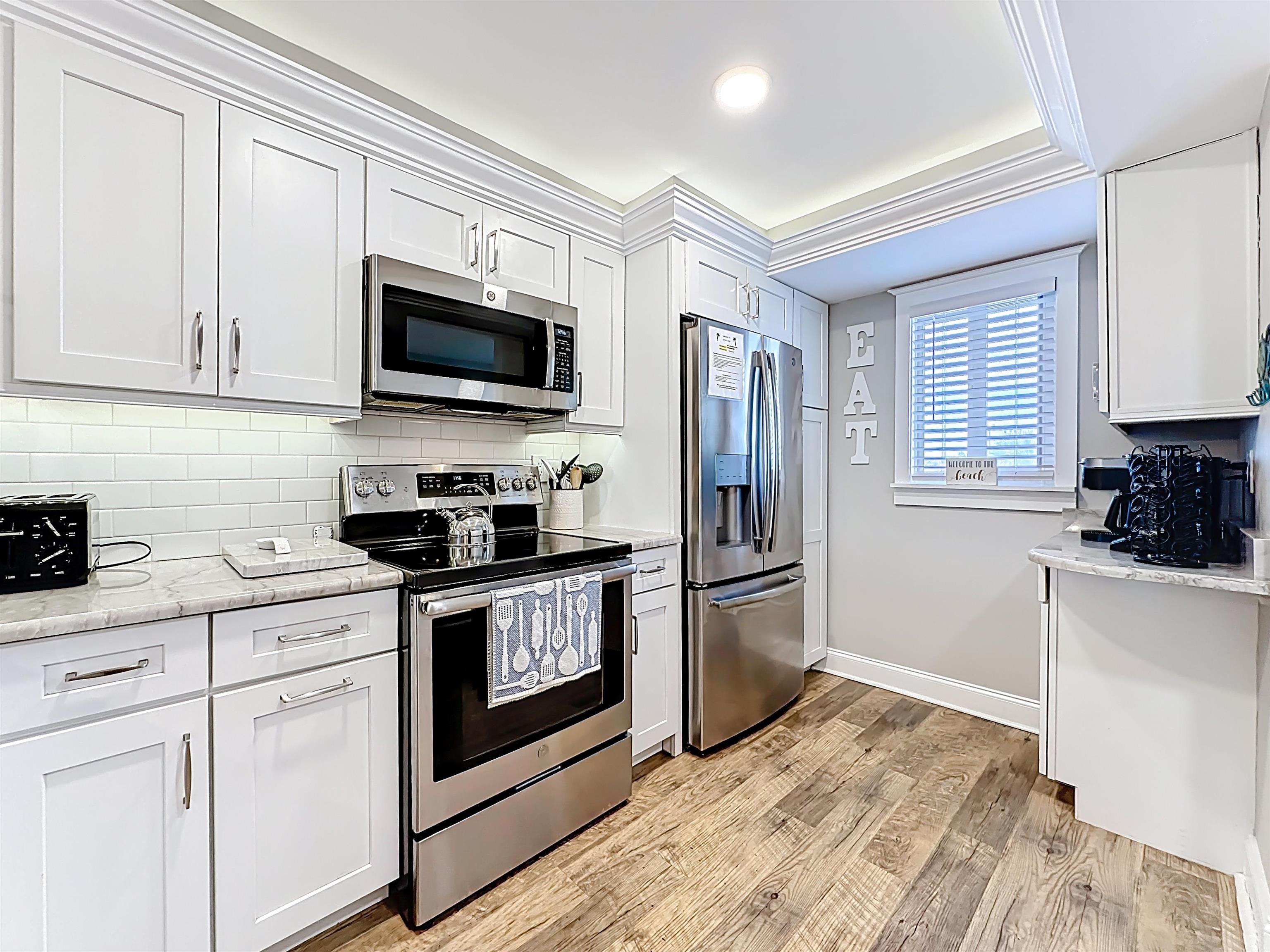 4 Ocean Trace Road, Unit 213 St. Augustine, FL 32080 - Photo 7 of 38 a kitchen with granite countertop white cabinets stainless steel appliances and sink