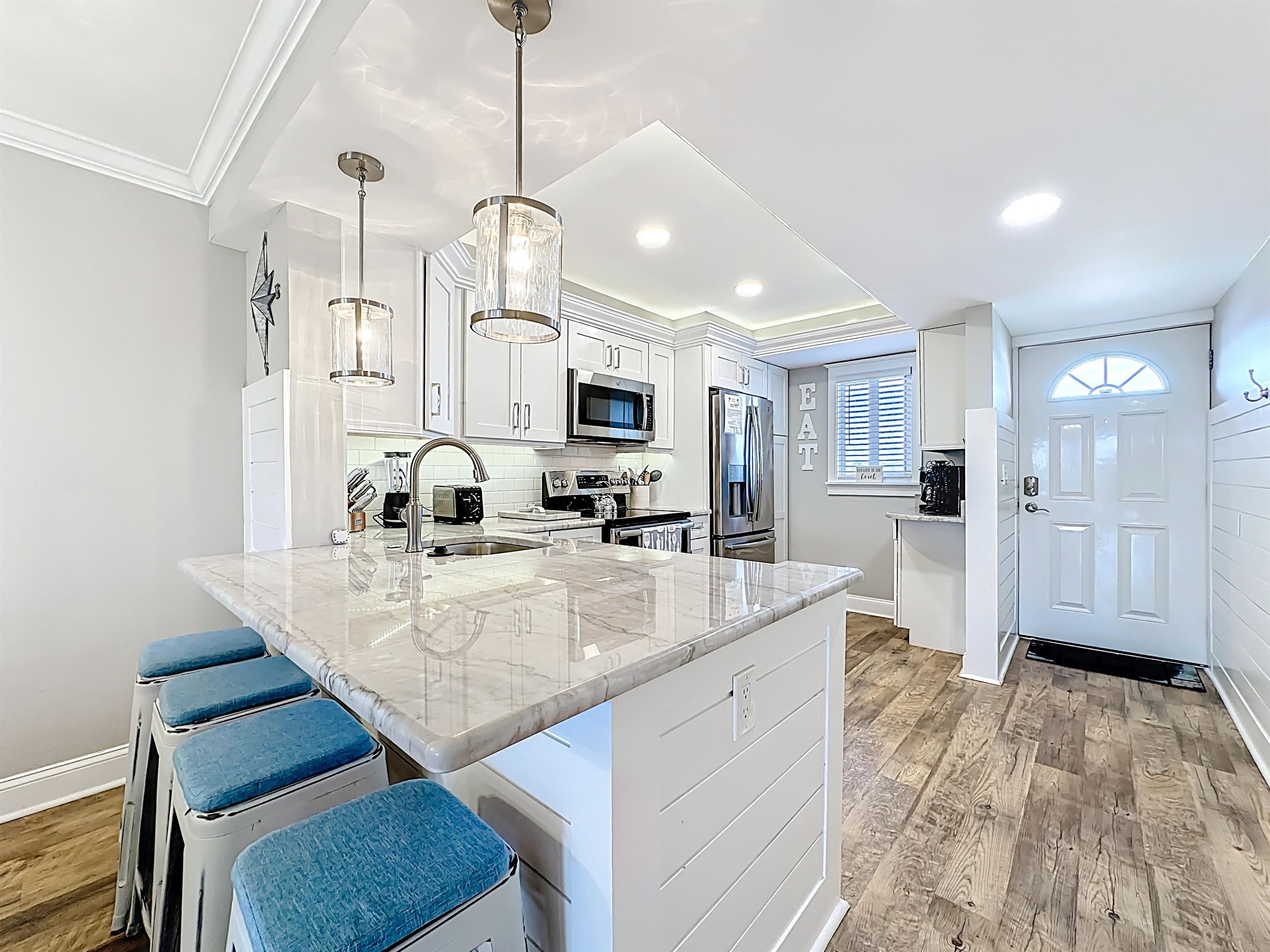4 Ocean Trace Road, Unit 213 St. Augustine, FL 32080 - Photo 10 of 38 a view of a kitchen with kitchen island granite countertop wooden floor stainless steel appliances and windows