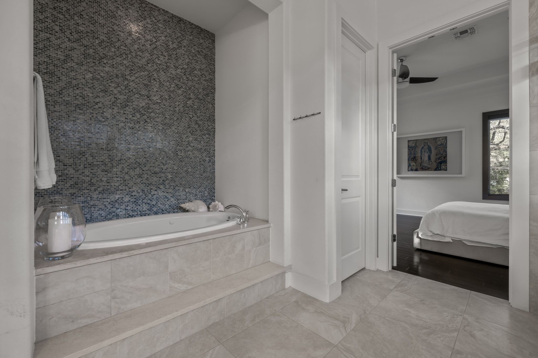 4720 Rockcliff Road, Unit 1 Austin, TX 78746 - Photo 26 of 39 Indulge in a relaxing soak within this primary bathroom's deep tub, framed by mosaic tile and rich flooring.