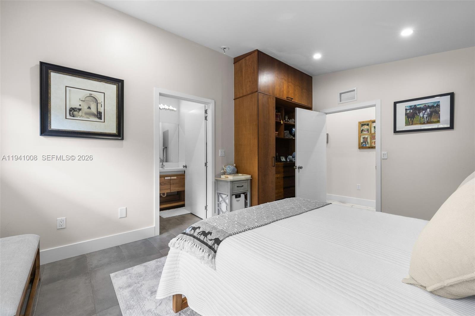 12033 Acme Road Wellington, FL 33414 - Photo 16 of 30 a bedroom with a bed and a large mirror