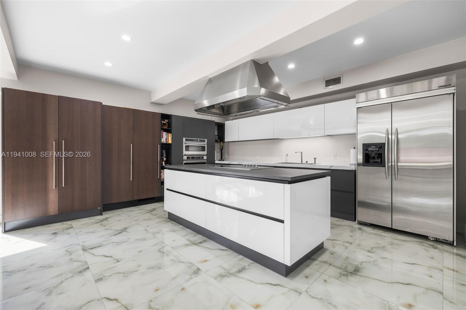 12033 Acme Road Wellington, FL 33414 - Photo 9 of 30 a kitchen with stainless steel appliances kitchen island granite countertop a refrigerator and a sink