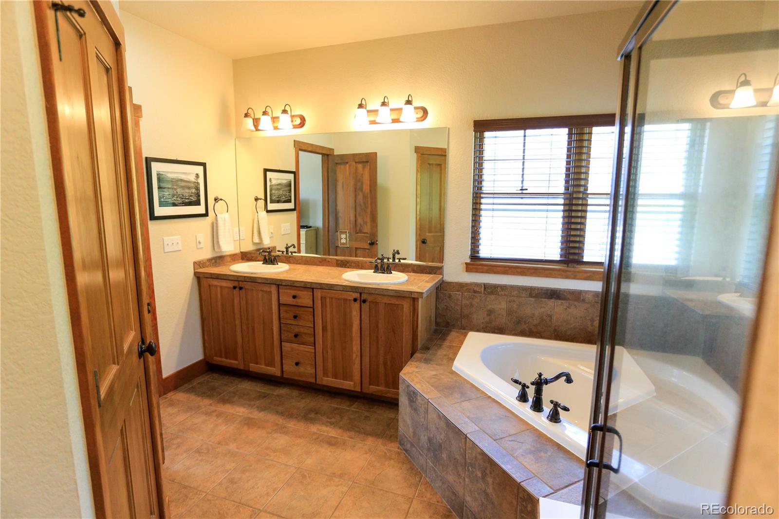 1324 Rendezvous Road Fraser, CO 80442 - Photo 21 of 36 a bathroom with a tub a sink and a large mirror next to a window