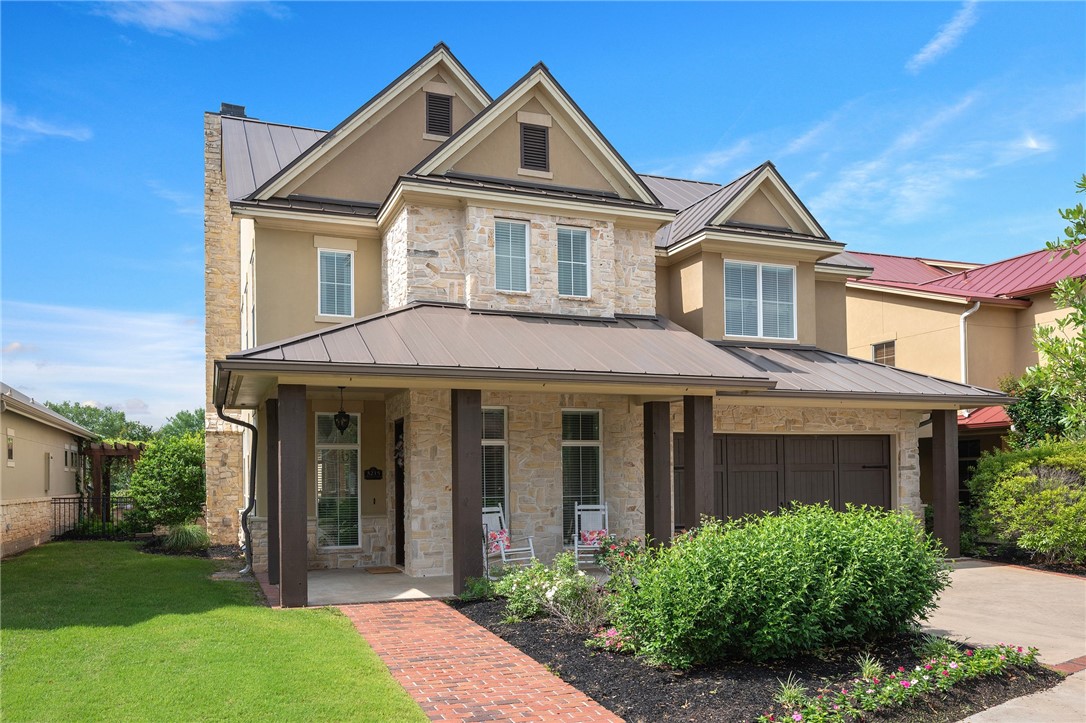 Townhome / multi-family property featuring a standing seam roof, stucco siding, stone siding, a porch, and metal roof