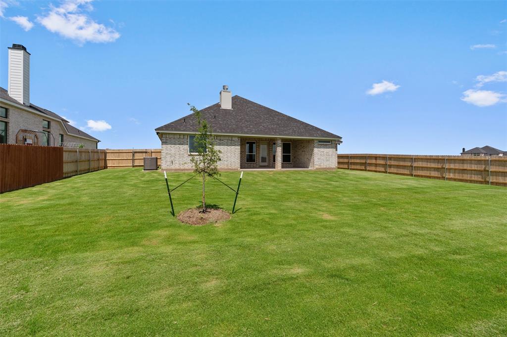 1341 Promised Land Road Hewitt, TX 76643 - Photo 27 of 29 Expansive backyard featuring a manicured lawn, a young tree, and a full privacy fence