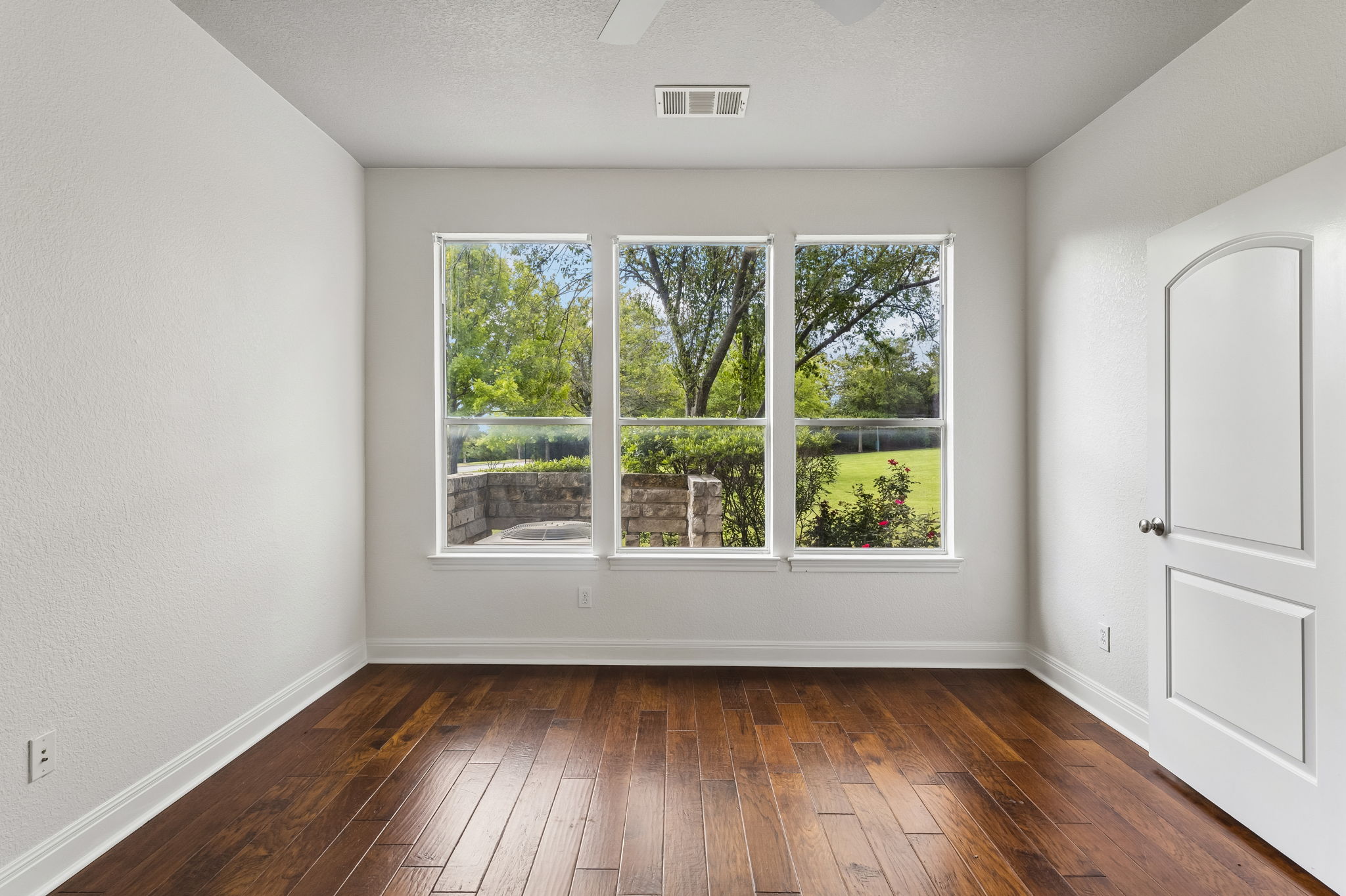 114 Aria Ridge, Unit 802 Lakeway, TX 78738 - Photo 10 of 37 Bright windows offer verdant garden views in this versatile room with rich hardwood flooring.