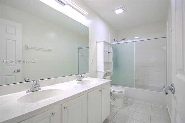 a bathroom with a granite countertop sink a toilet and shower