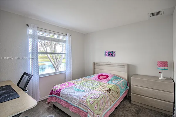 a bedroom with a bed a window and dresser