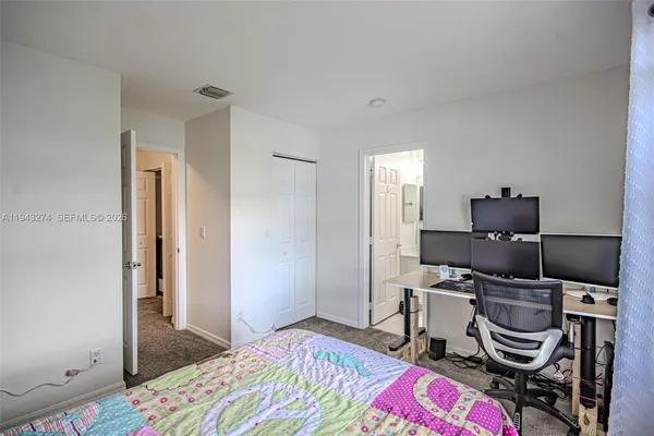 a bedroom with a bed and a desk in it