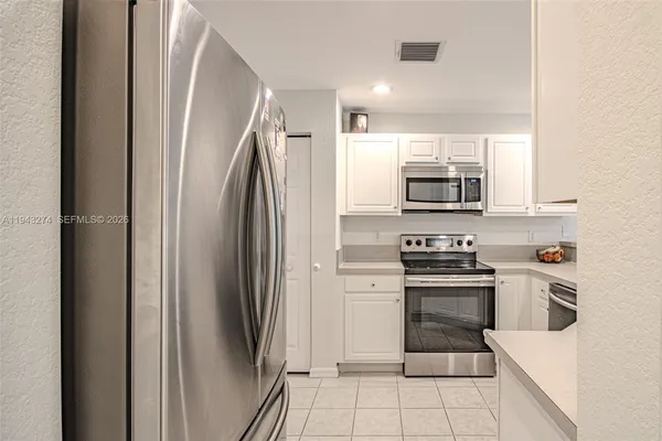 a kitchen with stainless steel appliances granite countertop a refrigerator and a sink