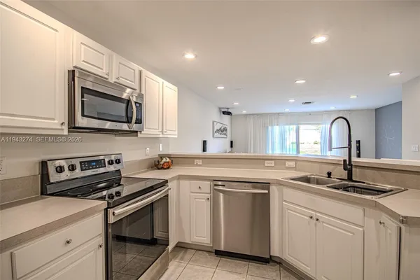 a kitchen with granite countertop a sink stainless steel appliances and cabinets